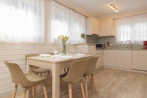 cocina con mesa de madera con sillas y comedor en Kotwica-Pobierowo Bukowa 6 en Pobierowo