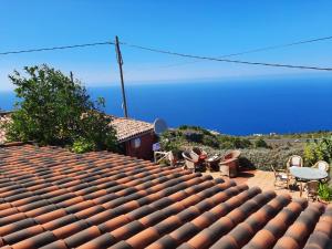 a roof of a house with chairs and a table at Finca Lomo de Castillo - Kleines Schlösschen am Berg in Icod de los Vinos