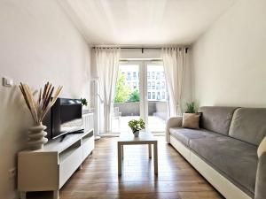 a living room with a couch and a tv at Matejki Apartment ~ Self Check-In 24 ~ Parking in Wrocław