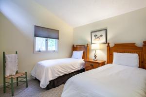 une chambre avec deux lits et une chaise et une fenêtre dans l'établissement Highland Forest Cabins Duo Cabin Retreat, à Pigeon Forge