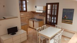 a kitchen with a white table and a table and chairs at Il Corbezzolo in Paciano