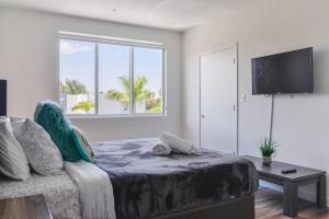 Schlafzimmer mit einem Bett, einem TV und einem Fenster in der Unterkunft Awesome Townhouse 15 minutes from the Beach in Miami