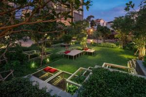a garden with a table and benches in the grass at Downtown Chic Condo Rooftop Pool #EN797 in Pattaya Central