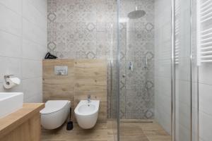 W łazience znajduje się toaleta i przeszklony prysznic. w obiekcie Kotwica-Pobierowo Bukowa 6 w Pobierowie