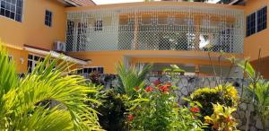dom z ogrodem przed nim w obiekcie Chaudhry Holiday House Montego Bay w mieście Montego Bay