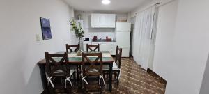 kuchnia ze stołem i krzesłami oraz białą lodówką w obiekcie Departamento Ushuaia 2 dormitorios w mieście Ushuaia
