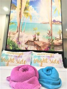 1 dormitorio con 2 almohadas y una foto de playa en AMNI Homestay Vista Bangi Muslim Preferred with COWAY Water, Microwave and FREE WIFI en Kajang