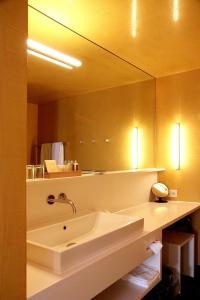 La salle de bains est pourvue d'un lavabo et d'un grand miroir. dans l'établissement Hotel Gasthof Krone, à Hittisau