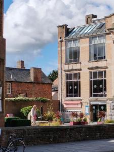 Eine Frau steht vor einem Backsteingebäude. in der Unterkunft Stunning 2-bed Listed Apartment in Taunton's historic centre in Taunton