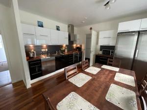 uma cozinha com uma mesa de jantar e uma cozinha com armários brancos em Pan Golf & Spa Villas em Imatra