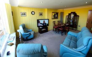 a living room with blue couches and a tv at Stunning 2-bed Listed Apartment in Taunton's historic centre in Taunton