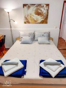 a bedroom with a bed with towels on it at Stefan Apartman in Novi Sad