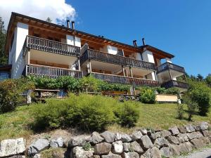 a house on a hill with a stone wall at Enzian 176 Al , Wohnung C3 in Tiefencastel +7 photos