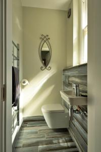La salle de bains est pourvue de toilettes, d'un lavabo et d'un miroir. dans l'établissement Finest Retreats - The Old Post Office Apartment 1, à Buxton