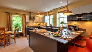 a kitchen with a large island with food on it at Finest Retreats - The Old Post Office Apartment 3 in Buxton
