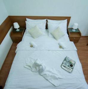 ein großes weißes Bett mit weißer Bettwäsche und Kissen in der Unterkunft Gec II in Ivanec Bistranski