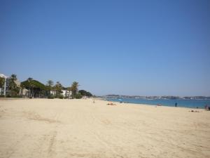 a beach with people laying on the sand and the water at Apartamentos Colibri in Cambrils