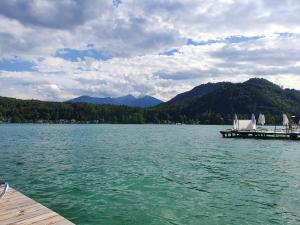 a view of a lake with a dock and mountains at Villa Blu in Sankt Kanzian