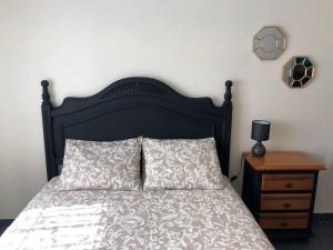 a bed with a black headboard and two pillows at La Duquesa del Valle in Cabezuela del Valle