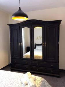 a bedroom with a black cabinet with a mirror at La Duquesa del Valle in Cabezuela del Valle