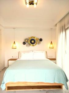 a bedroom with a bed and a clock on the wall at Lux Suite Sea Front Avra in Pefkohori