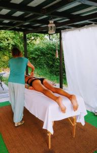 a woman is helping a woman laying on a bed at Notte Rosa Suites & Relax in Fornovo di Taro