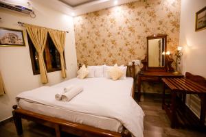 a bedroom with a bed with a mirror and a table at Hotel Cecil in Kolkata