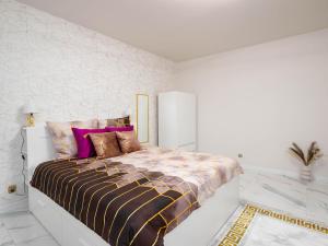 biała sypialnia z dużym łóżkiem i kolorowymi poduszkami w obiekcie Apartament Gold Aleja NMP 8 - Free parking w mieście Częstochowa