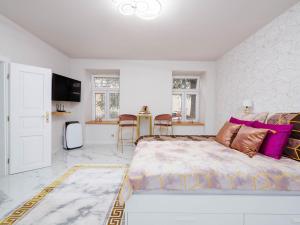 a bedroom with a large bed with purple pillows at Apartament Gold Aleja NMP 8 - Free parking in Częstochowa