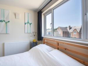 a bedroom with a bed and a large window at Ayla in Lyme Regis