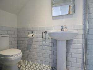 a white bathroom with a toilet and a sink at Ayla in Lyme Regis