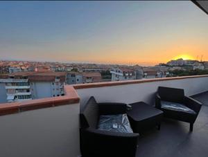 einen Balkon mit zwei Stühlen und einer Couch und einem Sonnenuntergang in der Unterkunft Residence Borghi in Scalea