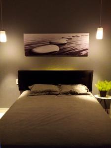 een slaapkamer met een bed en een schilderij aan de muur bij flat Luiz Carlos Mouzinho in Teresina