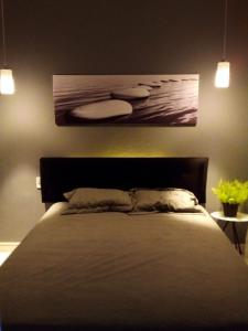a bedroom with a bed and a painting on the wall at flat Luiz Carlos Mouzinho in Teresina