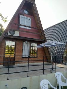 Casa con patio con 2 sillas y sombrilla en Cabaña Abuelo Ernesto 1 en Colón
