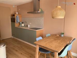 cocina y comedor con mesa de madera y sillas en 't Paviljoenhûs bij Sneekermeer, en Offingawier