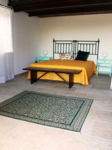 a bedroom with a bed with a table and a rug at Masseria Marico in Castellaneta