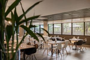 ein Restaurant mit Tischen und Stühlen und einer Topfpflanze in der Unterkunft Intercity Canoas in Canoas