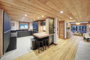 kuchnia i salon z drewnianym sufitem w obiekcie Chalet Whymper avec piscine 150m téléphérique (neuf 2021) w mieście Megève