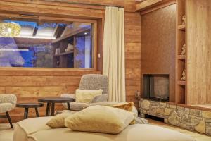 salon z kanapą i kominkiem w obiekcie Chalet Whymper avec piscine 150m téléphérique (neuf 2021) w mieście Megève