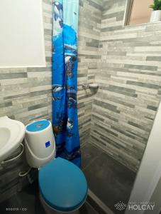 a bathroom with a blue toilet and a shower at Hospedaje Holcay in Bogotá
