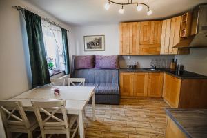 a kitchen and a living room with a table and a couch at Eko Pony Ranch Ogrizek in Podčetrtek
