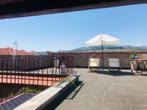 a patio with two chairs and an umbrella at Janelas da Cabreira in Campos