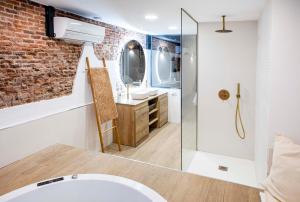 ein Badezimmer mit einer Backsteinwand und einem Waschbecken in der Unterkunft Calle Amparo 86 Lujoso Dúplex con Jacuzzi en Lavapies especial parejas in Madrid