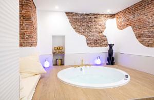 eine Badewanne in einem Zimmer mit Ziegelwand in der Unterkunft Calle Amparo 86 Lujoso Dúplex con Jacuzzi en Lavapies especial parejas in Madrid