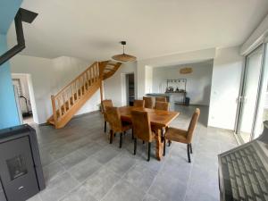a dining room with a table and chairs and a staircase at Duo des Falaises in Octeville-sur-Mer