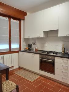 cocina con armarios blancos y fogones en Appartamento Poli, en Castiglione dei Pepoli