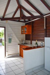a kitchen with wooden cabinets and a white counter top at Gîtes du Domaine de la Canne à Sucre in Anse-Bertrand