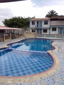 une grande piscine en face d'un bâtiment dans l'établissement Finca Hotel La Marina, à Quimbaya