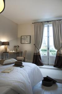 Un dormitorio con una gran cama blanca y una ventana en Les Buis de Boscherville Gite, en Hénouville